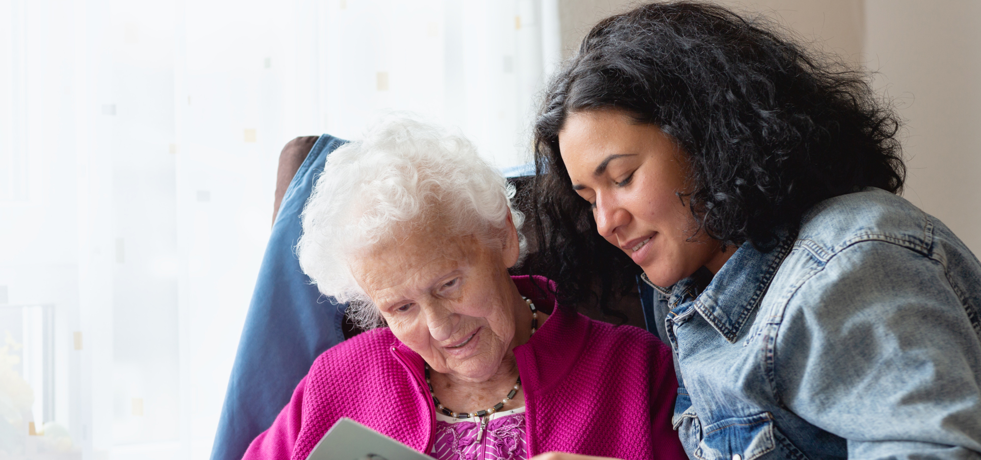 female family member reading with a senior woman